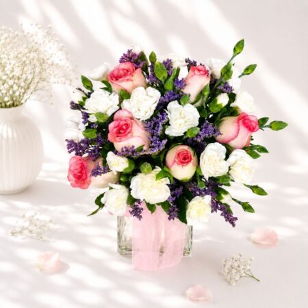 Premium pink rose, white eustoma and purple statice flower arrangement in a glass vase for flower delivery in Bangalore.