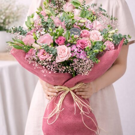 Premium pink rose and eustoma bouquet with baby’s breath and eucalyptus wrapped in blush fabric by FreshKnots Bangalore with same day delivery.