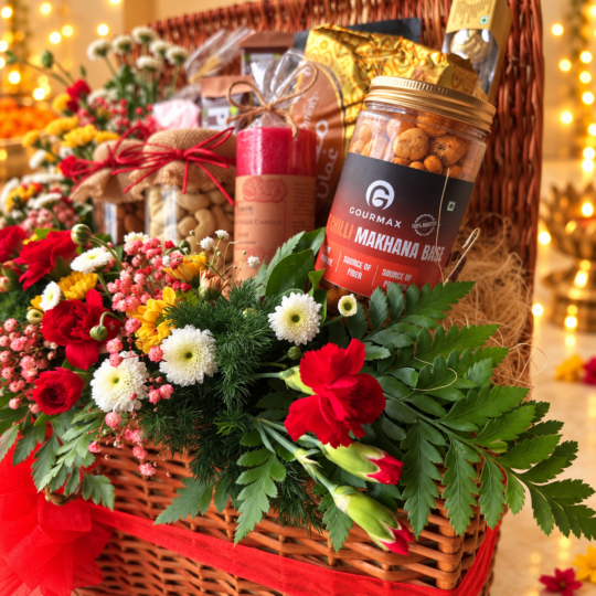 Gourmax Lime Chilli Makhana Bhel jar, scented pillar candle and dry fruit jars in a wicker hamper with red carnations, side view