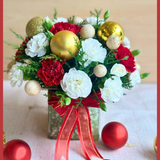Christmas floral arrangement in glass vase with red white flowers and gold accents by premium florist in Bangalore