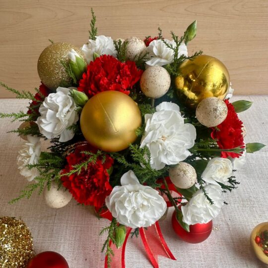 Christmas floral arrangement in glass vase with red white flowers and gold accents by premium florist in Bangalore
