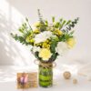 Mother’s Day yellow and white fresh flower arrangement in glass vase with roses, carnations and eucalyptus by local florist