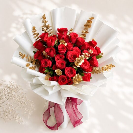 Luxury red rose bouquet with golden eucalyptus accents and premium wrapping for anniversary and birthday flower delivery in Bangalore.