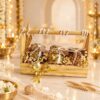 Golden Knot dry fruit hamper with cashews and almonds in glass jars on a wooden tray with handle, angled view