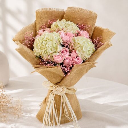 Elegant hydrangea bouquet with pastel roses, baby’s breath, and rustic burlap wrapping for premium flower delivery in Bangalore.