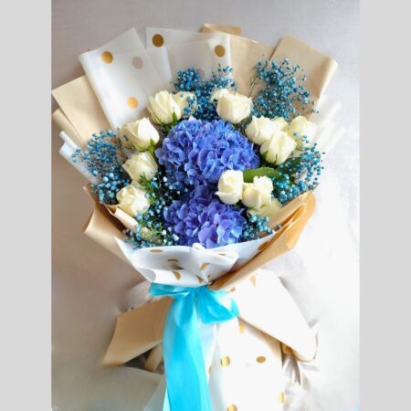 Blue hydrangea and white rose bouquet with baby’s breath, wrapped in polka dot paper – same day flower delivery in Bangalore