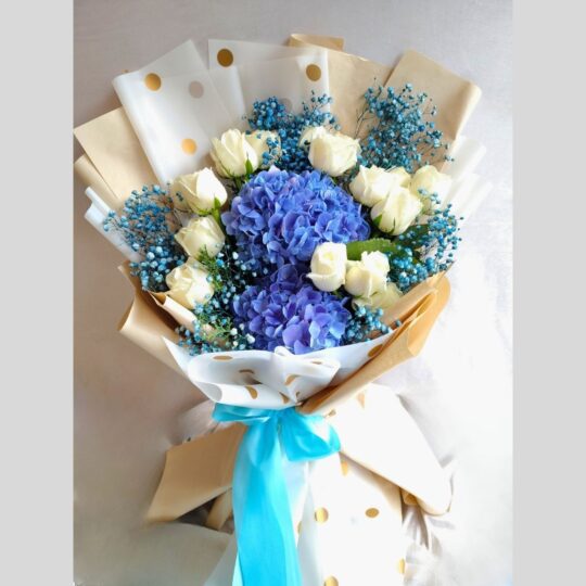 Blue hydrangea and white rose bouquet with baby’s breath, wrapped in polka dot paper – same day flower delivery in Bangalore