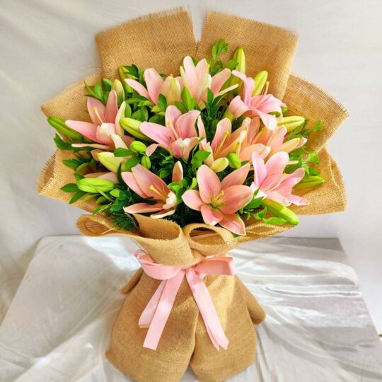Pink lily bouquet wrapped in jute with green foliage – perfect for birthday gifts, anniversary flowers, and same day flower delivery in Bengaluru.
