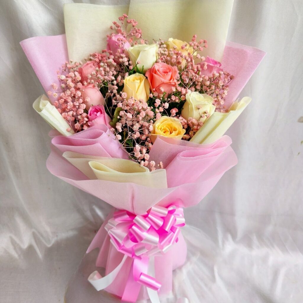 FreshKnots mixed rose bouquet with pink, yellow, and cream roses wrapped in designer paper – available for same day flower delivery in Bengaluru.