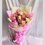 FreshKnots mixed rose bouquet with pink, yellow, and cream roses wrapped in designer paper – available for same day flower delivery in Bengaluru.