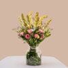 Vase arrangement featuring eustoma, tuberose, and mixed greens in a clear glass vase.