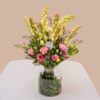 Vase arrangement featuring eustoma, tuberose, and mixed greens in a clear glass vase.