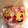 A vibrant mixed rose bouquet with pink, yellow, and white roses, elegantly wrapped in blush and gold paper with a satin bow — available for same day flower delivery in Bangalore.
