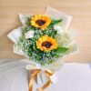 A cheerful sunflower bouquet paired with white carnations and baby’s breath, elegantly wrapped in cream paper with a golden ribbon — available for same day flower delivery in Bangalore.