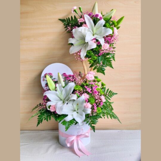 A pastel floral arrangement in a glass vase featuring white hydrangeas, yellow and pink roses, white daisies, and pink fillers, tied with a white ribbon — ideal for same day flower delivery in Bangalore.
