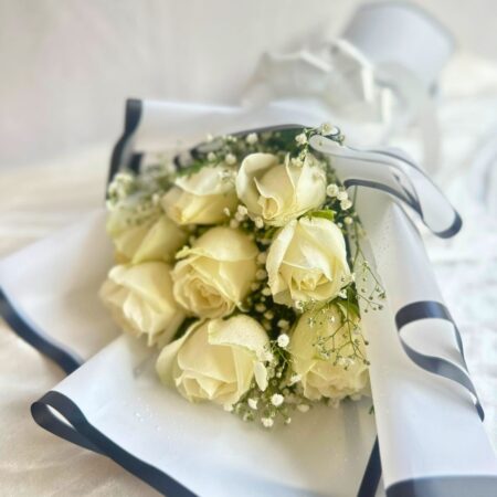 A bouquet of fresh white roses wrapped in elegant white paper with a satin bow — available for same day flower delivery in Bangalore.