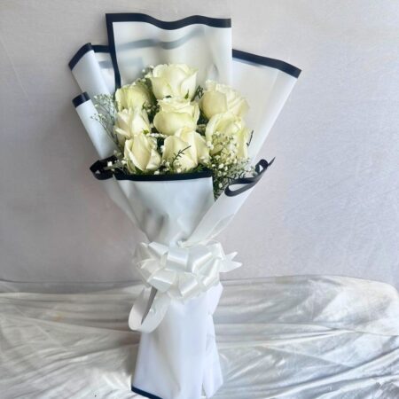 A bouquet of fresh white roses wrapped in elegant white paper with a satin bow — available for same day flower delivery in Bangalore.