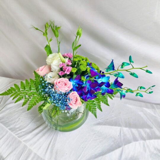 Exotic fishbowl flower arrangement with blue orchids, pink roses, and eustoma – same-day delivery in Bangalore by FreshKnots