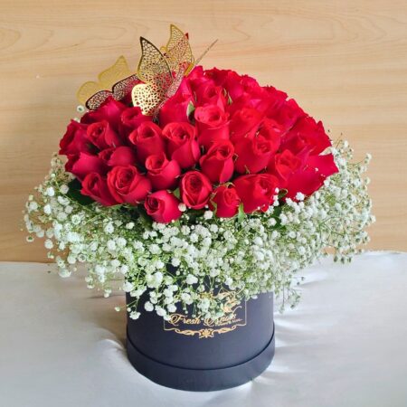 “Black hatbox with a dome of red roses surrounded by baby’s breath and decorated with golden butterflies.”