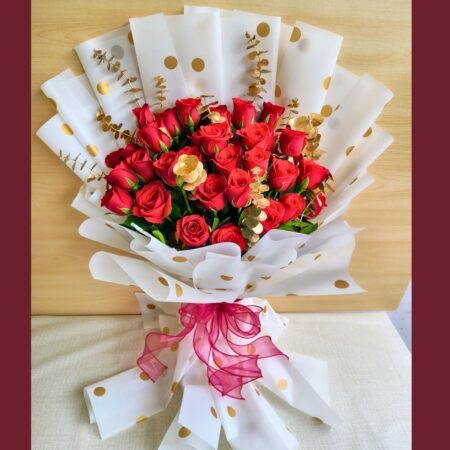 Red rose bouquet with golden accents and white polka-dot wrapping – premium romantic flowers by FreshKnots, same-day delivery in Bangalore.