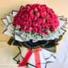 Luxury bouquet of 100 fresh red roses with white fillers, handcrafted by FreshKnots Bangalore.