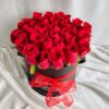 Red roses arranged in a black hatbox with a red ribbon, luxury rose box by Fresh Knots for gifting and same-day flower delivery in Bangalore.