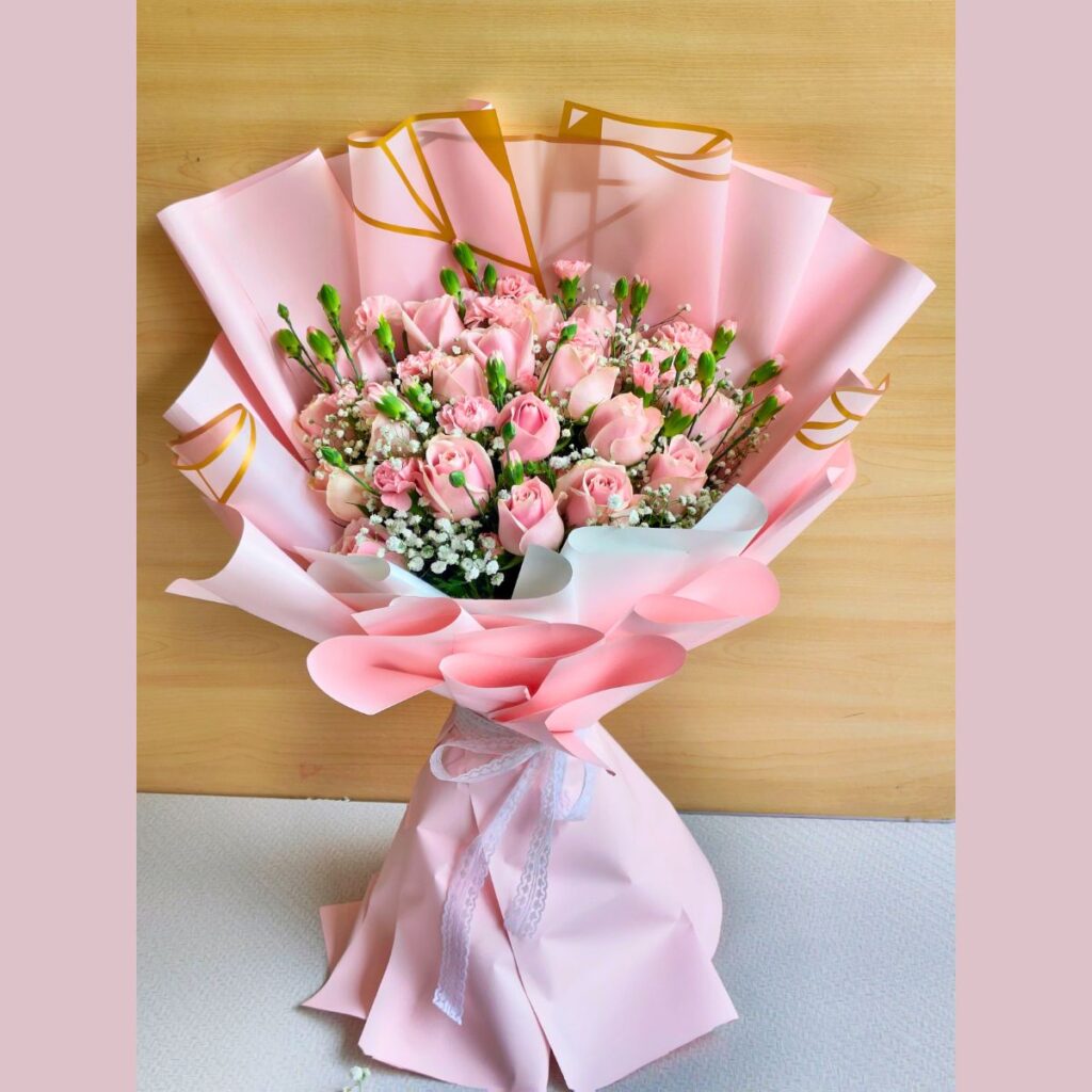 Soft pink rose bouquet with baby’s breath and delicate fillers, wrapped in pastel pink paper for an elegant floral gift