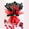 Red rose and carnation Valentine bouquet with black and gold wrapping and red ribbon in Bangalore