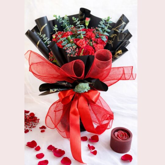 Red rose and carnation Valentine bouquet with black and gold wrapping and red ribbon in Bangalore