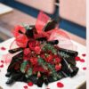 Red rose and carnation Valentine bouquet with black and gold wrapping and red ribbon in Bangalore