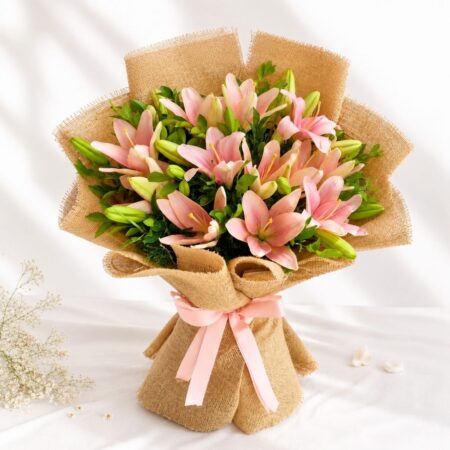 Pink lily bouquet wrapped in jute with green foliage – perfect for birthday gifts, anniversary flowers, and same day flower delivery in Bengaluru.
