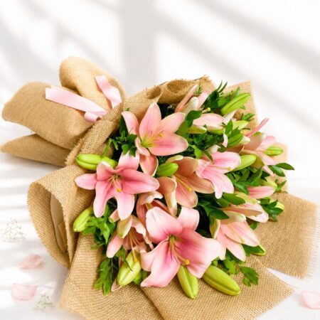 Pink lily bouquet wrapped in jute with green foliage – perfect for birthday gifts, anniversary flowers, and same day flower delivery in Bengaluru.