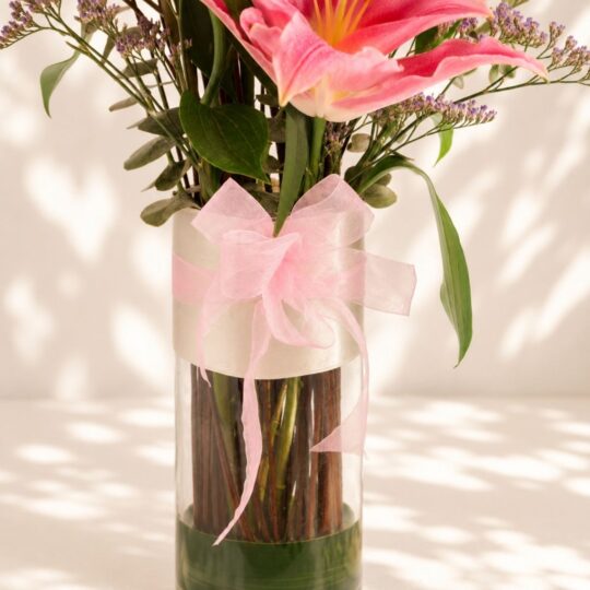 Premium pink lilies in glass vase arrangement with fresh flowers for luxury flower delivery in Bangalore.