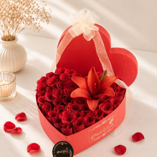 Luxury heart-shaped flower box with fresh red roses and red lily for Valentine's Day, anniversary and romantic flower delivery in Bangalore.