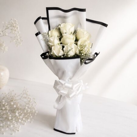 A bouquet of fresh white roses wrapped in elegant white paper with a satin bow — available for same day flower delivery in Bangalore.