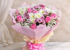 Pink rose and white chrysanthemum bouquet with baby’s breath wrapped in blush pink paper and satin ribbon.