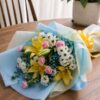 Fresh flower bouquet Bangalore with yellow lilies, daisies and pink accents in blue wrapping
