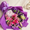 Luxury pink lily and hydrangea bouquet in purple wrap for flower delivery in Bangalore