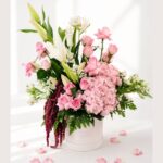 Premium blush pink flower arrangement with roses, hydrangea, white lilies, and fresh greens in a white box