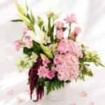 Premium blush pink flower arrangement with roses, hydrangea, white lilies, and fresh greens in a white box