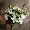 Luxury white lily bouquet in European hand tied style with fresh greenery by FreshKnots Bangalore.