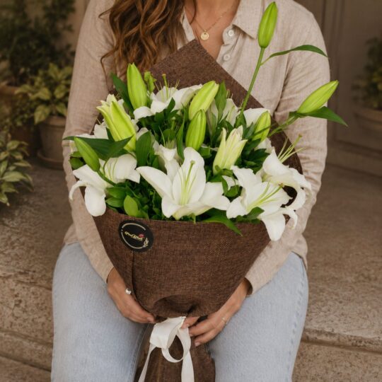 Luxury white lily bouquet in European hand tied style with fresh greenery by FreshKnots Bangalore.