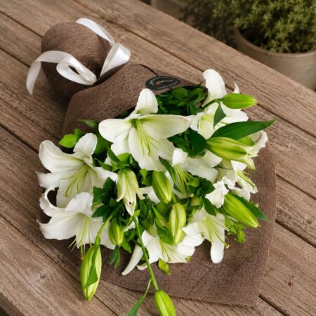 Luxury white lily bouquet in European hand tied style with fresh greenery by FreshKnots Bangalore.