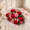 Close-up of red roses and pink carnations in anniversary bouquet
