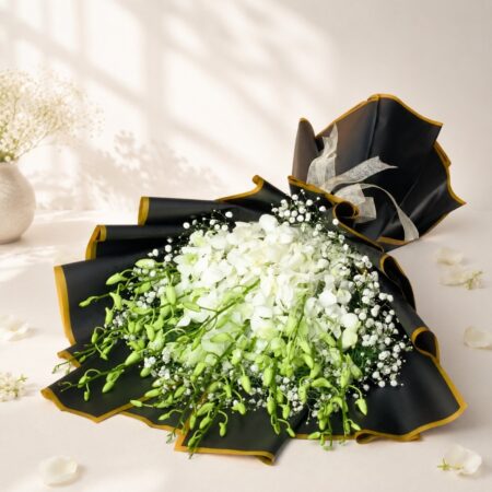 White orchid bouquet lying flat, black and gold wrap Bangalore
