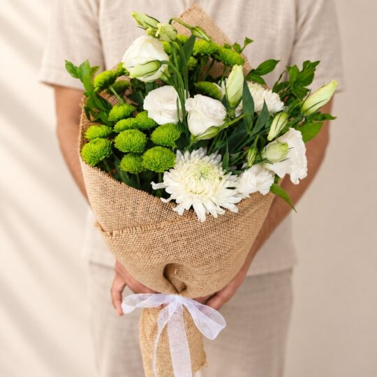 White and green mixed cut flowers bunch held, Bangalore