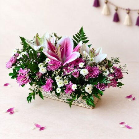 Diwali lily centrepiece in Bangalore with pink oriental lilies, white Calimero and purple chrysanthemums on a jute-wrapped base