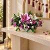 Pink lily and purple chrysanthemum centrepiece on a marble console