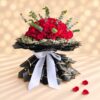 Large red rose hand bouquet in layered black and gold wrap with a white satin ribbon, side angle