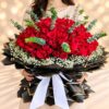Woman holding the Crimson Crown bouquet of 200 red roses, showing its size against her body